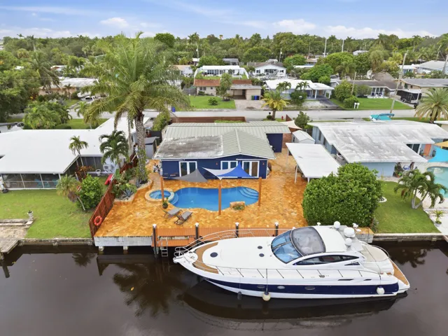 Waterfront property with a private dock, blue exterior, swimming pool, and adjacent hot tub