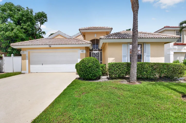 Single-story residence featuring a tile roof, stucco exterior, and an attached two-car garage
