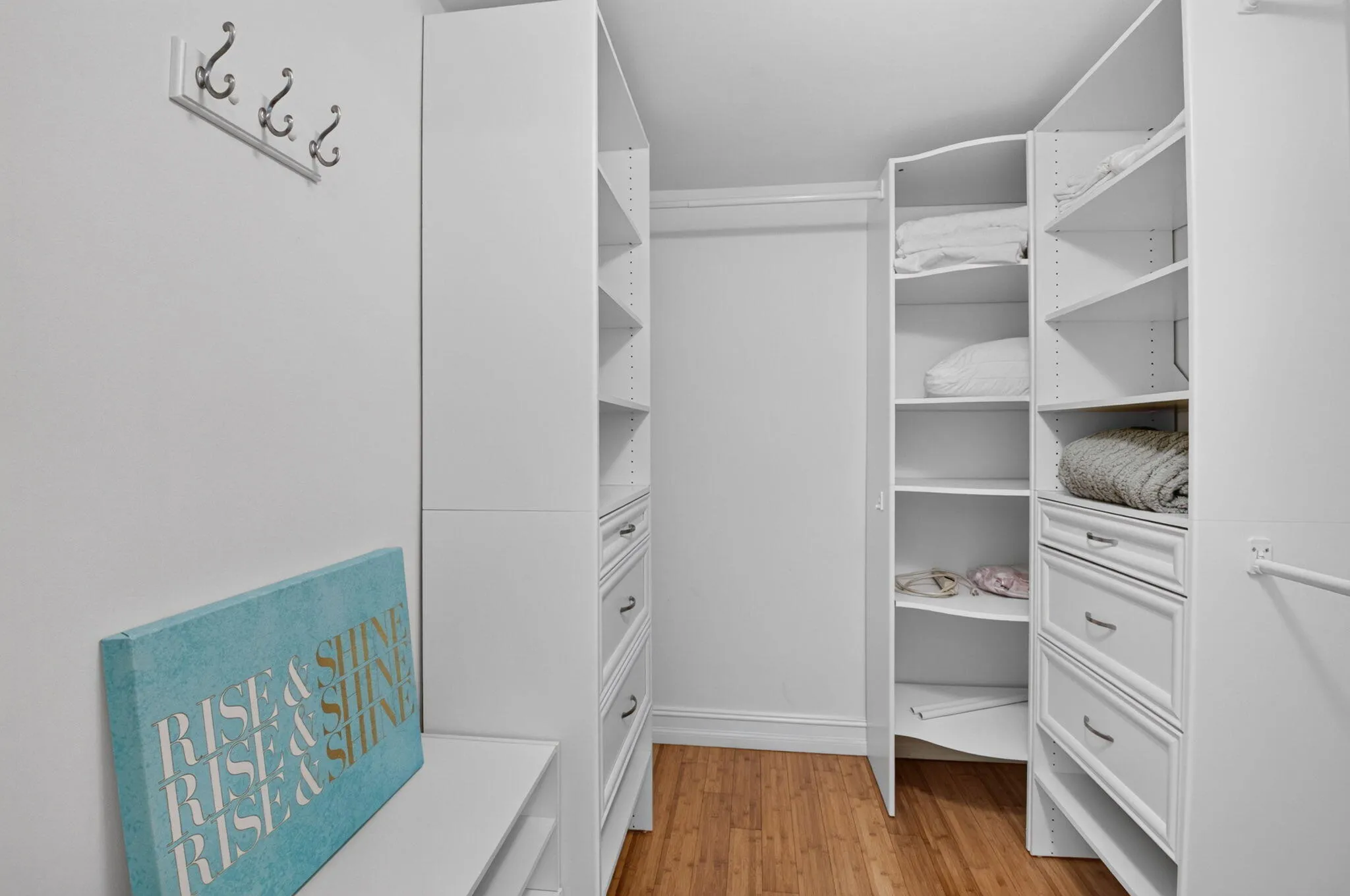 Custom closet system with white cabinetry, integrated shelving, and drawer storage