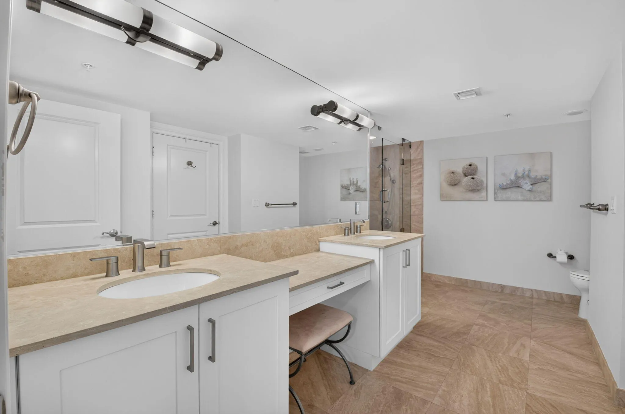 Dual vanity with undermount sinks, stone countertops, and polished nickel fixtures