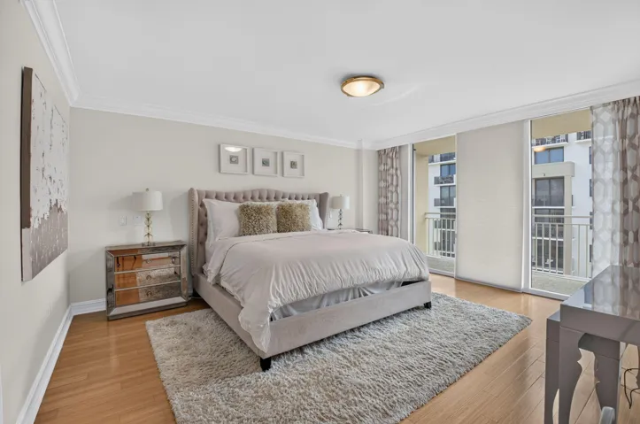Hardwood flooring, crown molding, double sliding glass doors, recessed lighting, and a private balcony with metal railings