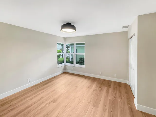 Wood-finish flooring, neutral wall tones, and a window floods the room with natural light