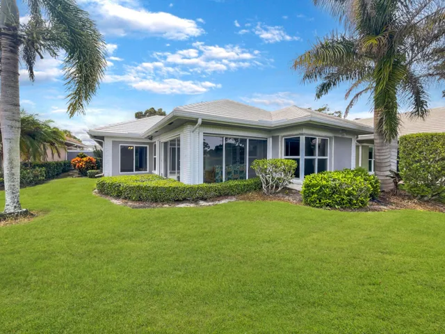 Expansive lawn with mature palm trees and sculpted hedges