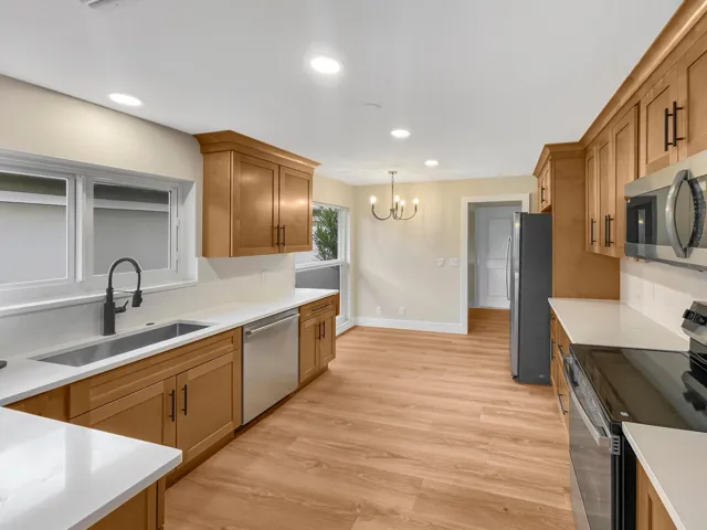 Kitchen featuring wood-finish cabinetry, stainless steel appliances, solid surface countertops, and recessed lighting