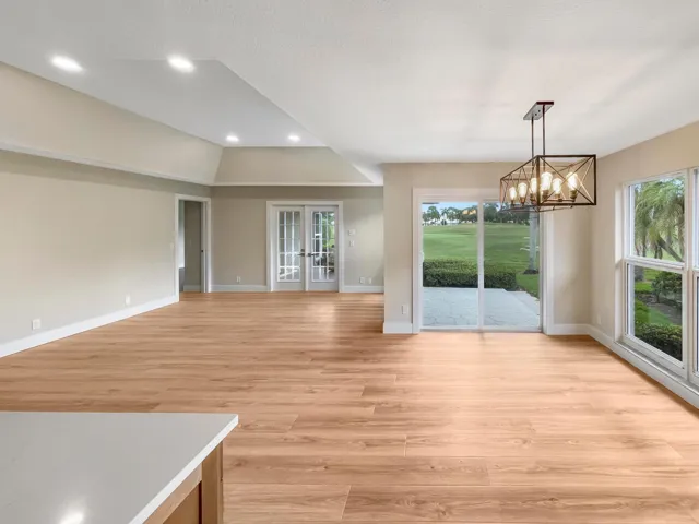 Wood-finish flooring throughout, recessed lighting, and a contemporary linear chandelier