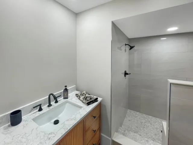Vanity with a built-in rectangular sink, quartz-finish countertop, and matte black faucet