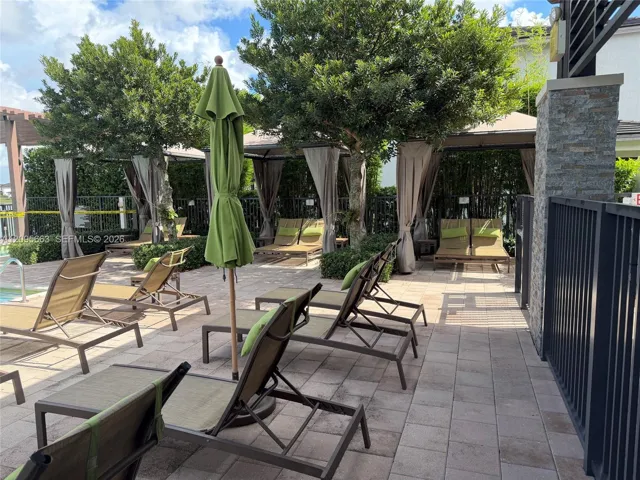 Paver patio featuring integrated structural gazebos, stone-accented pillars, and mature landscaping