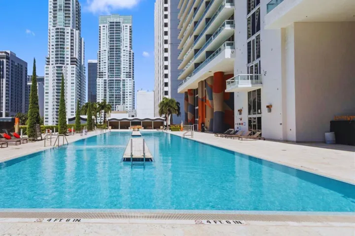Resort-style pool with integrated sundeck, surrounded by an expansive pool deck