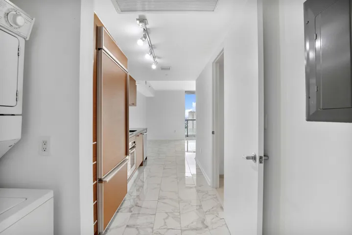Laundry on the left, bathroom on the right, kitchen straight ahead, bay and city at the end of the hall. Thirty seconds from the elevator to that view.
