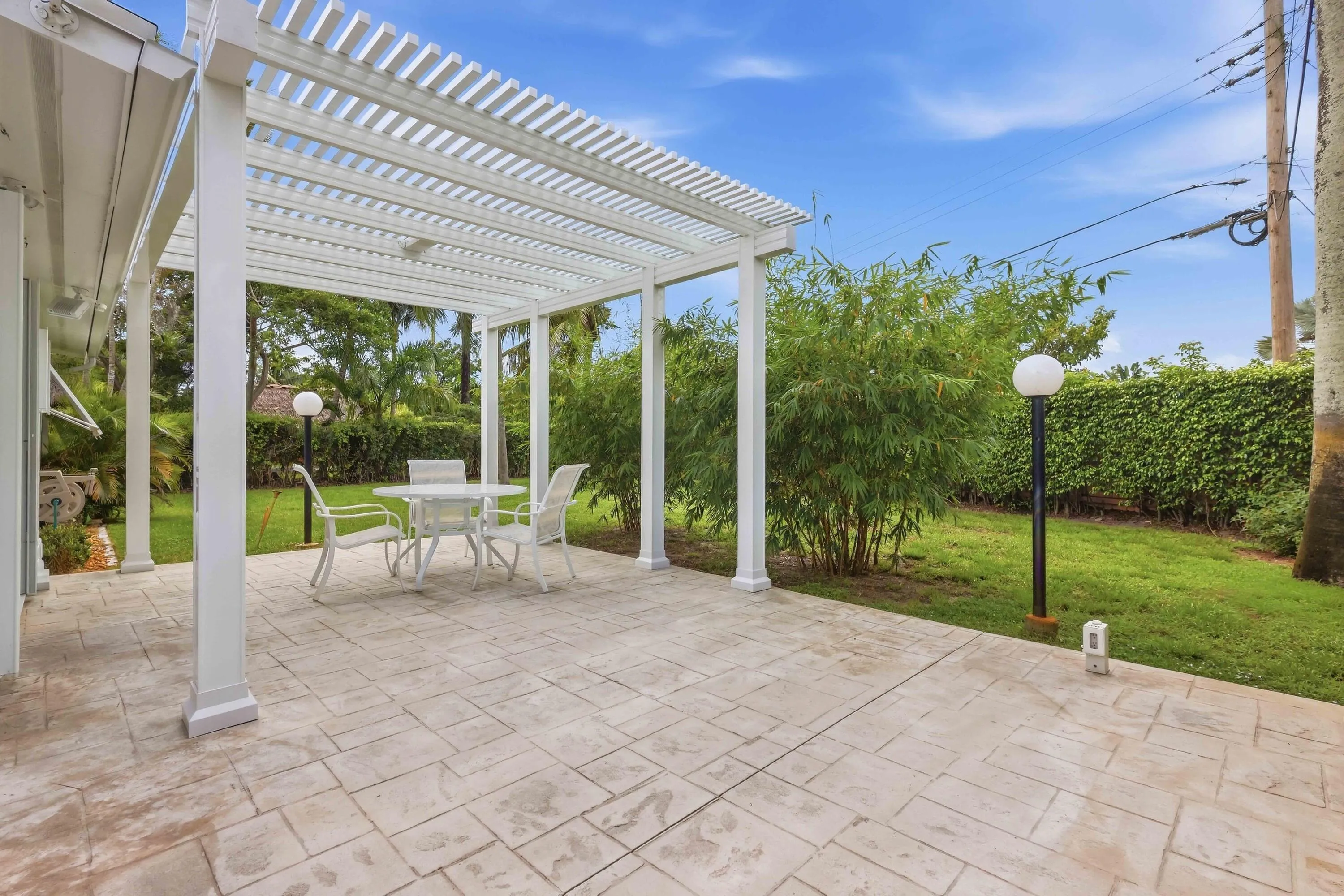 Stamped concrete patio with a white pergola