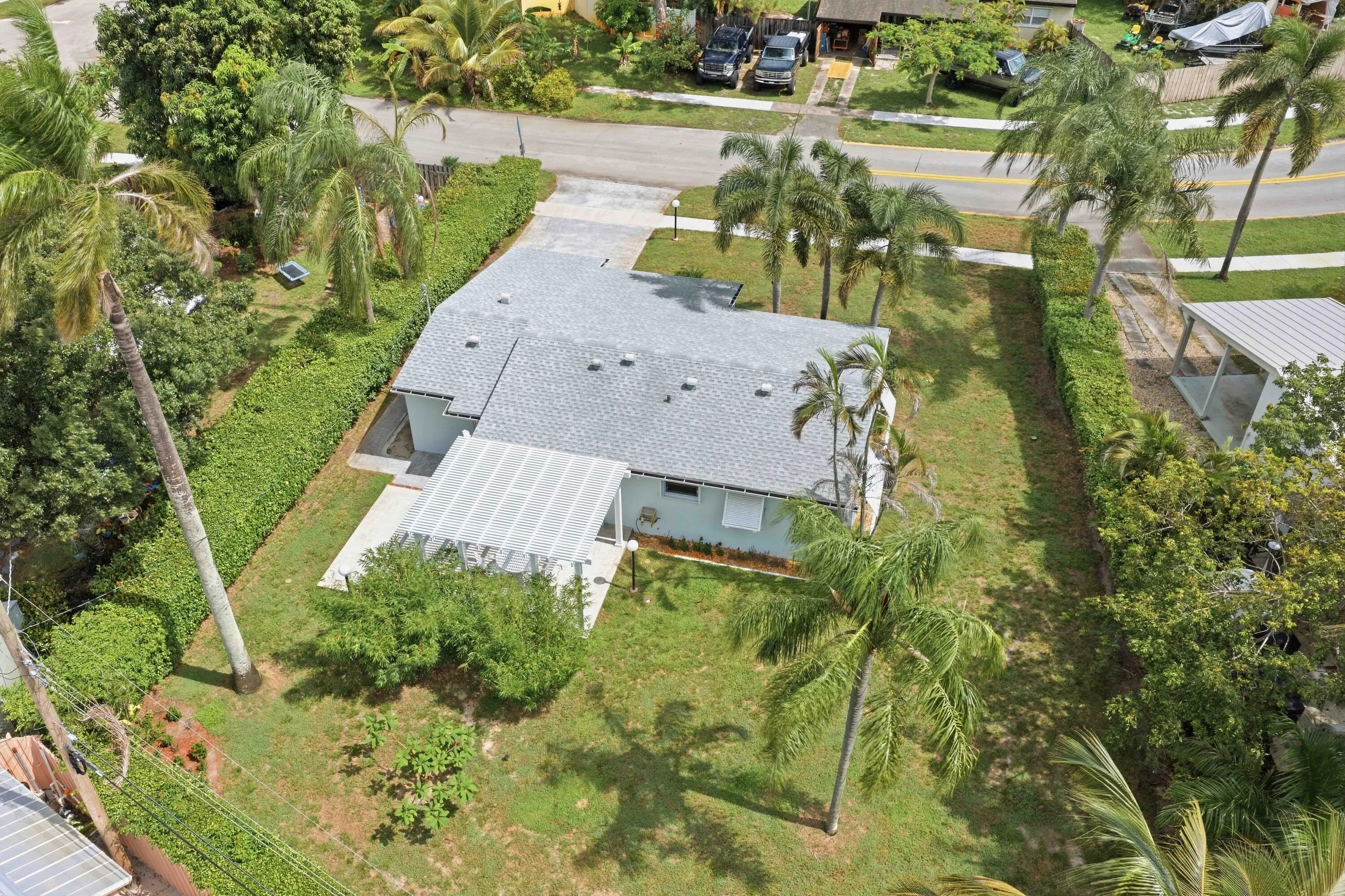 Light blue exterior with a gray shingle roof and a white slatted patio cover