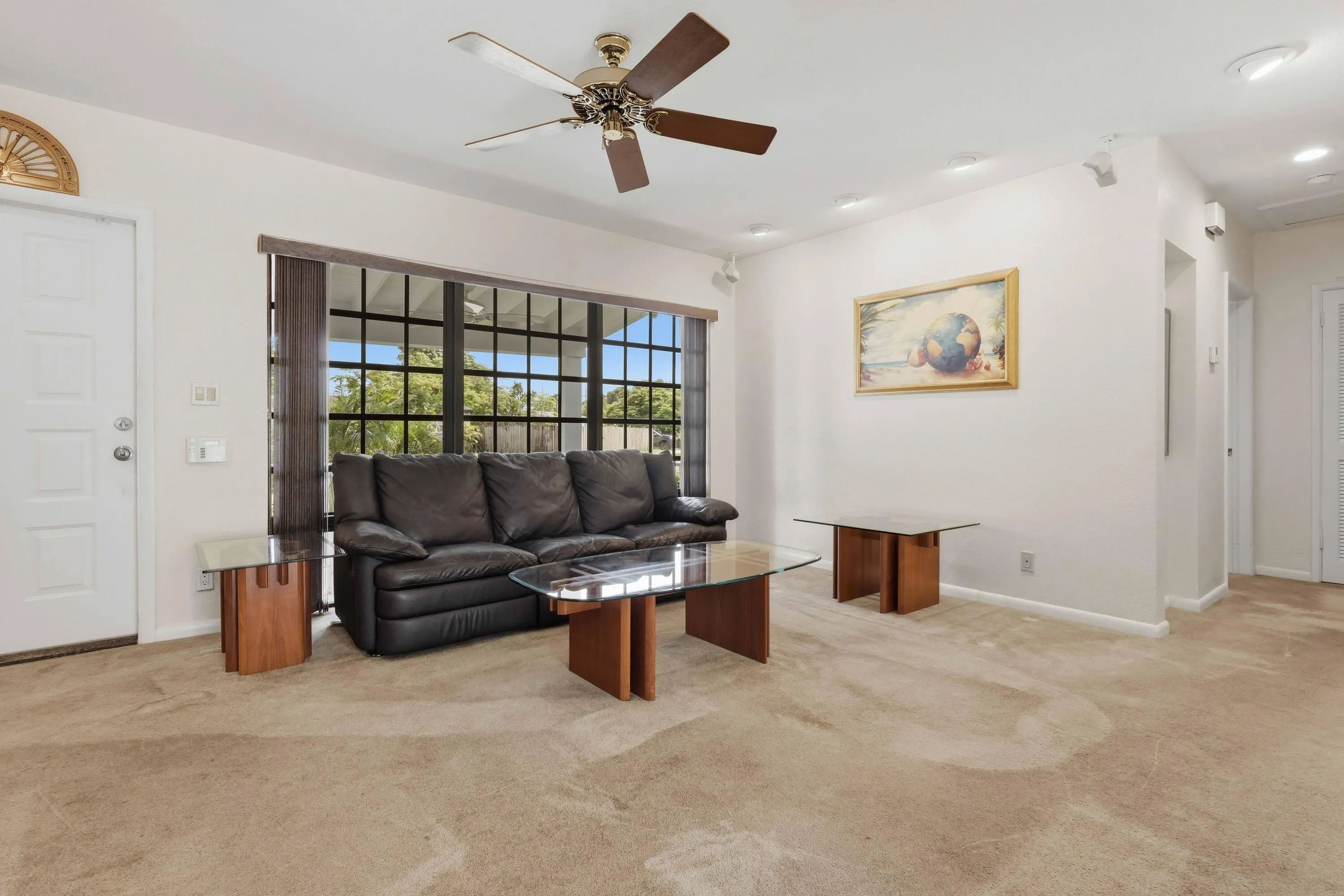 Recessed lighting, ceiling fan, expansive window with grid pattern, neutral wall paint, and beige carpeting