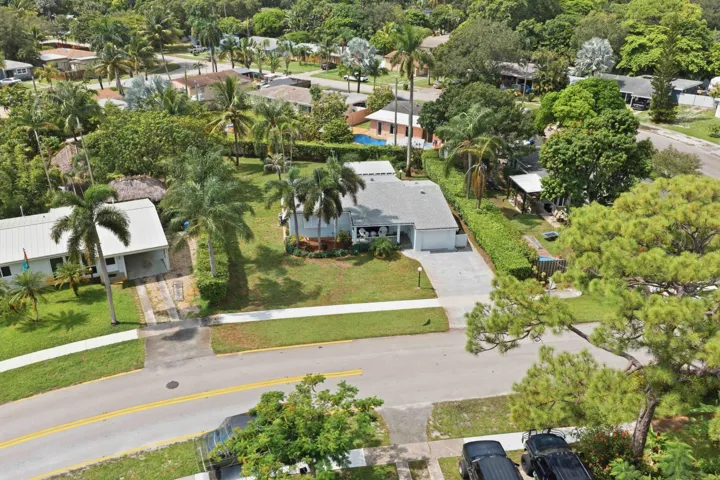Single-story residence with an attached garage, paved driveway, and mature landscaping