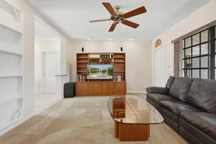 Recessed lighting, ceiling fan with wood-finish blades, and built-in wood-finish entertainment center
