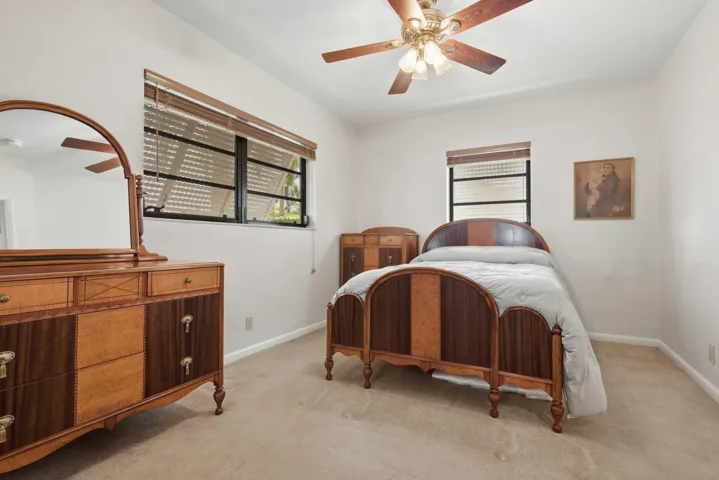 Neutral wall paint with carpeted flooring and ceiling fan