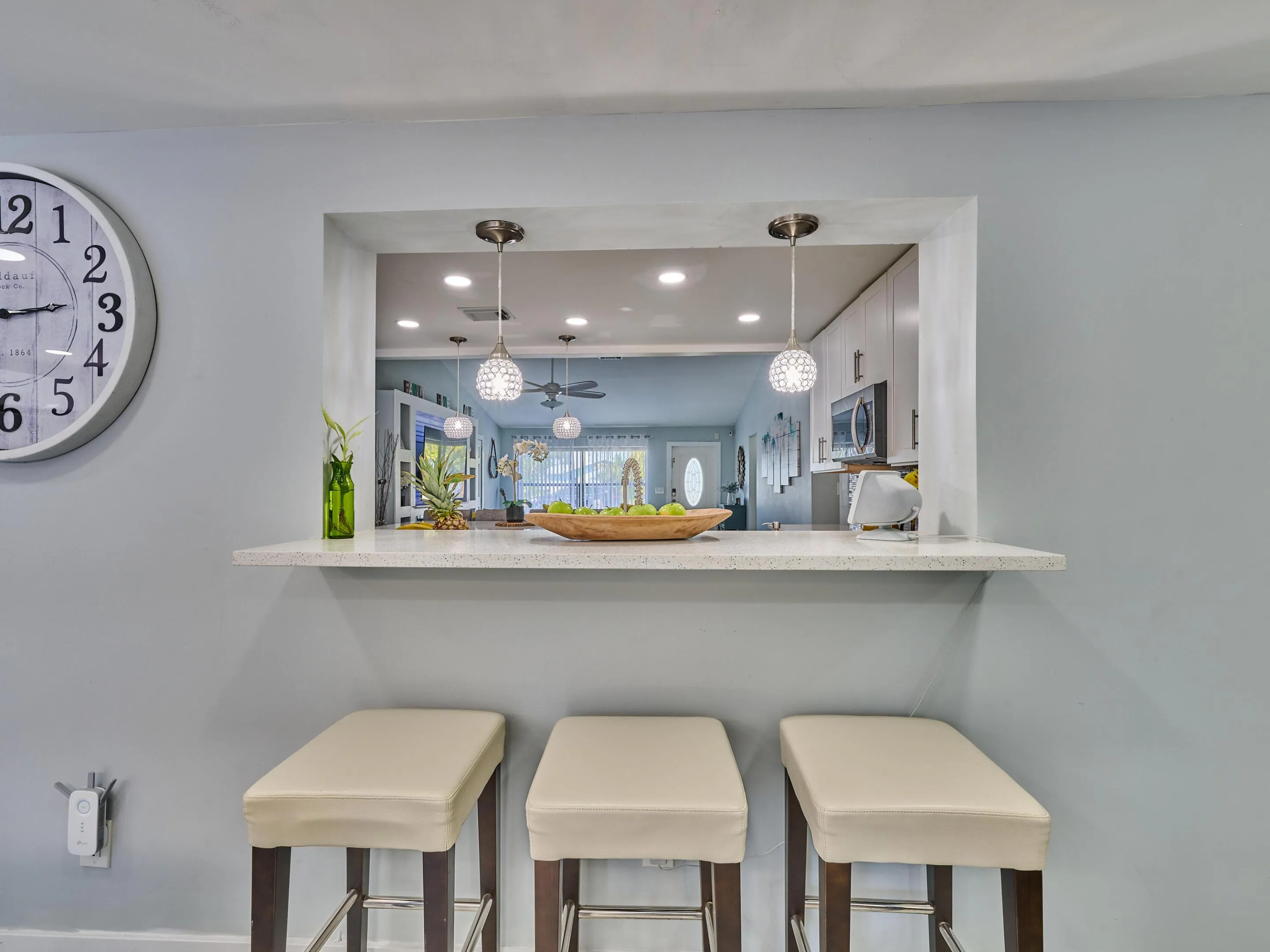 Pass-through window featuring a stone finish countertop and two pendant light fixtures
