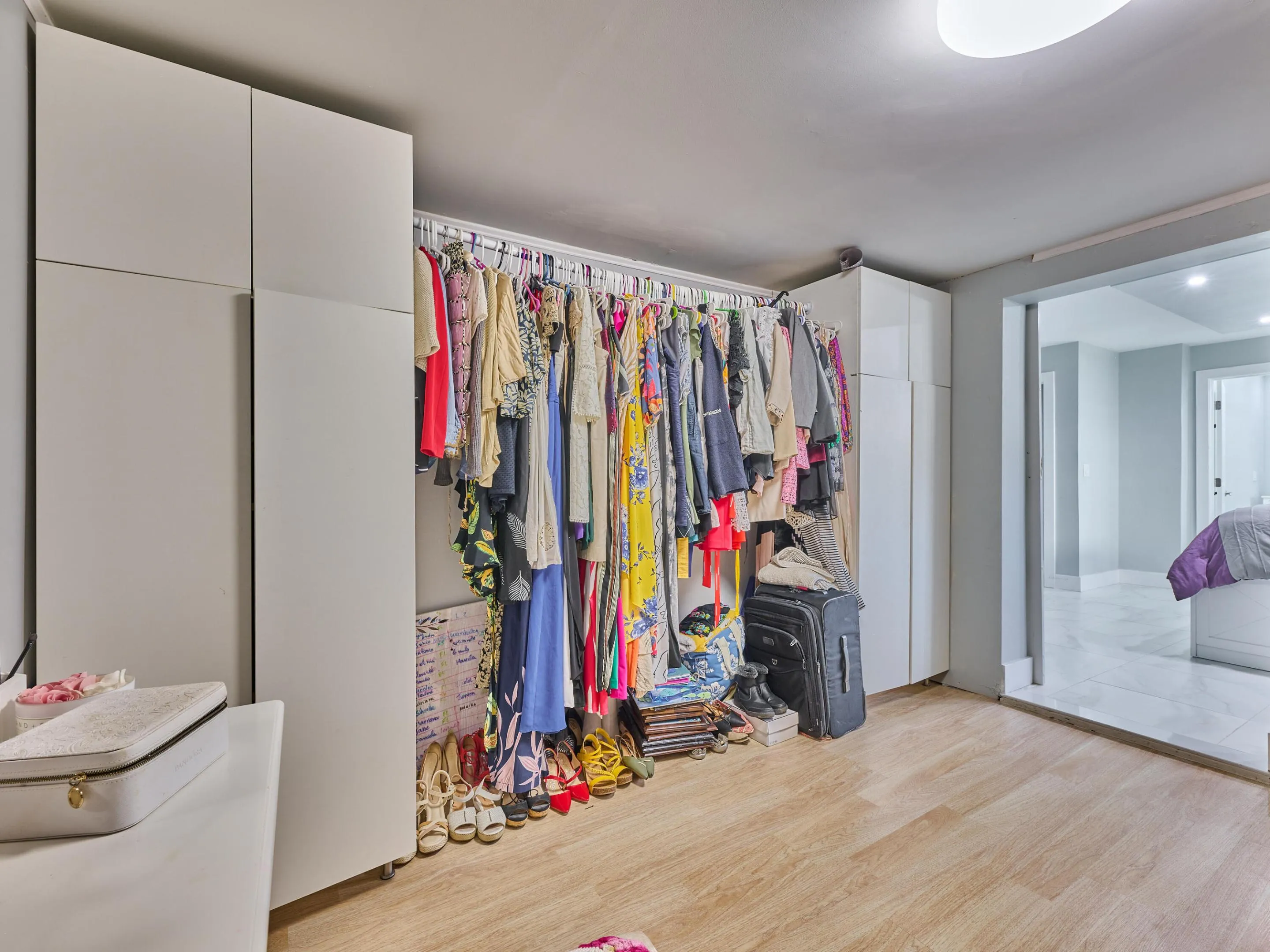 Wood-finish flooring, built-in white cabinetry, recessed ceiling lighting, and a wide entryway