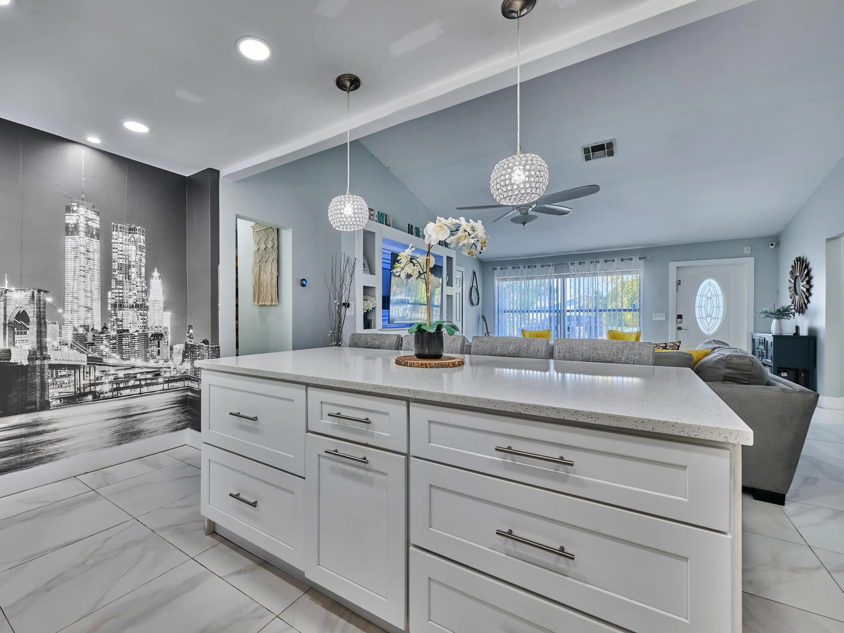 Kitchen island with white shaker-style cabinetry, a light-toned countertop, and recessed lighting