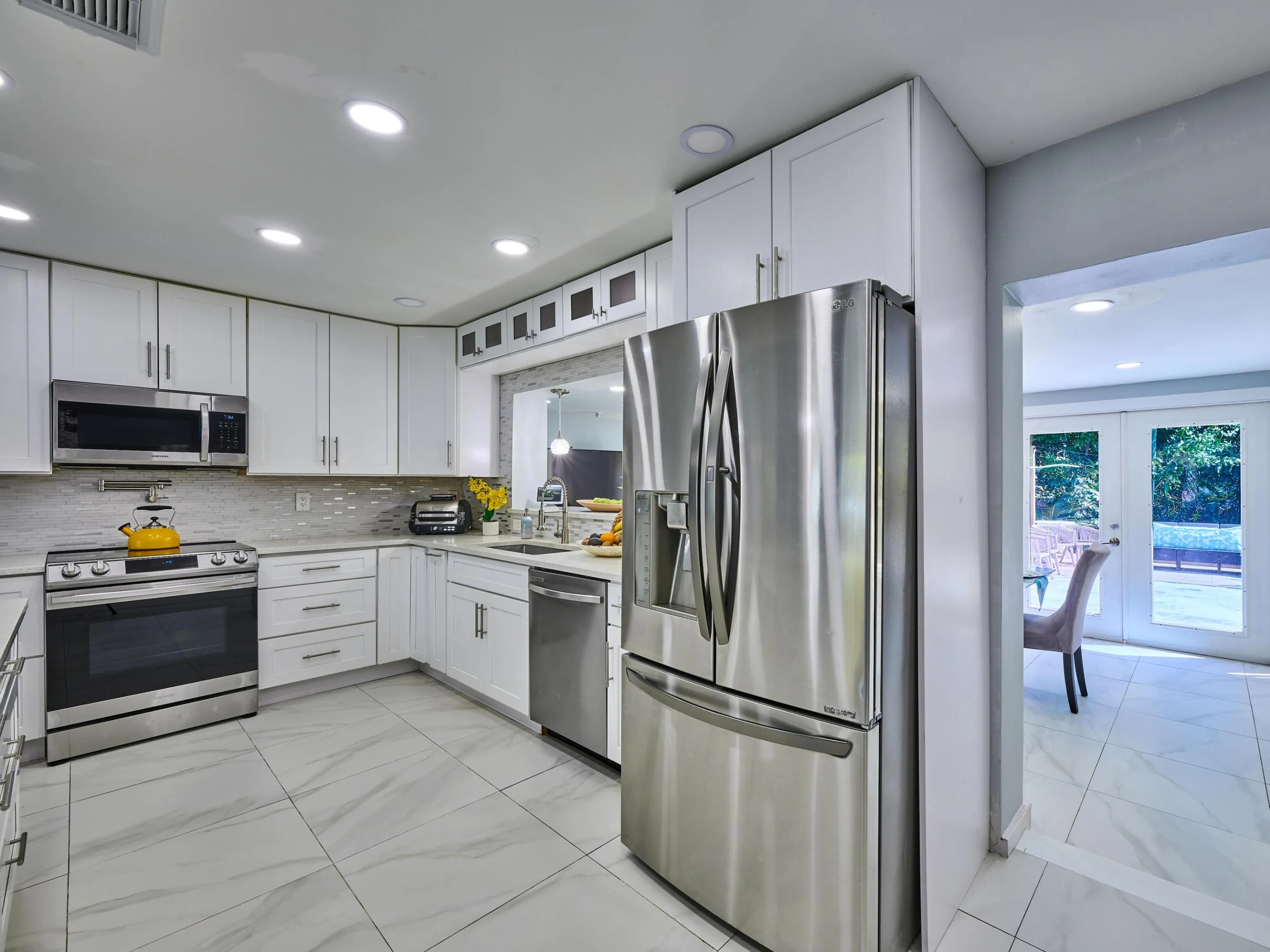 Kitchen featuring recessed lighting, white cabinetry, stainless steel appliances, and a tile backsplash