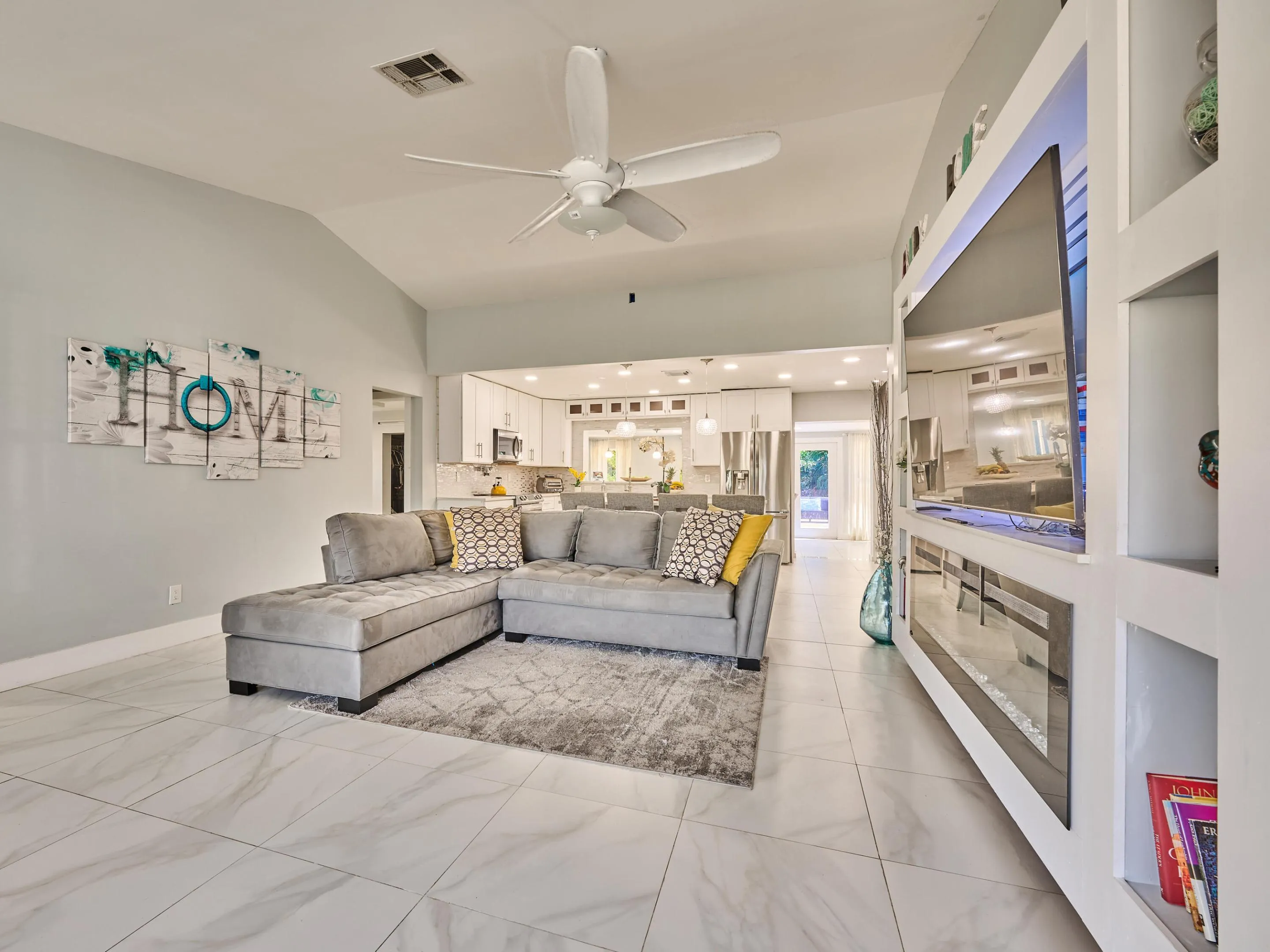 Vaulted ceiling, ceiling fan, large format tile flooring, built-in entertainment center, recessed lighting