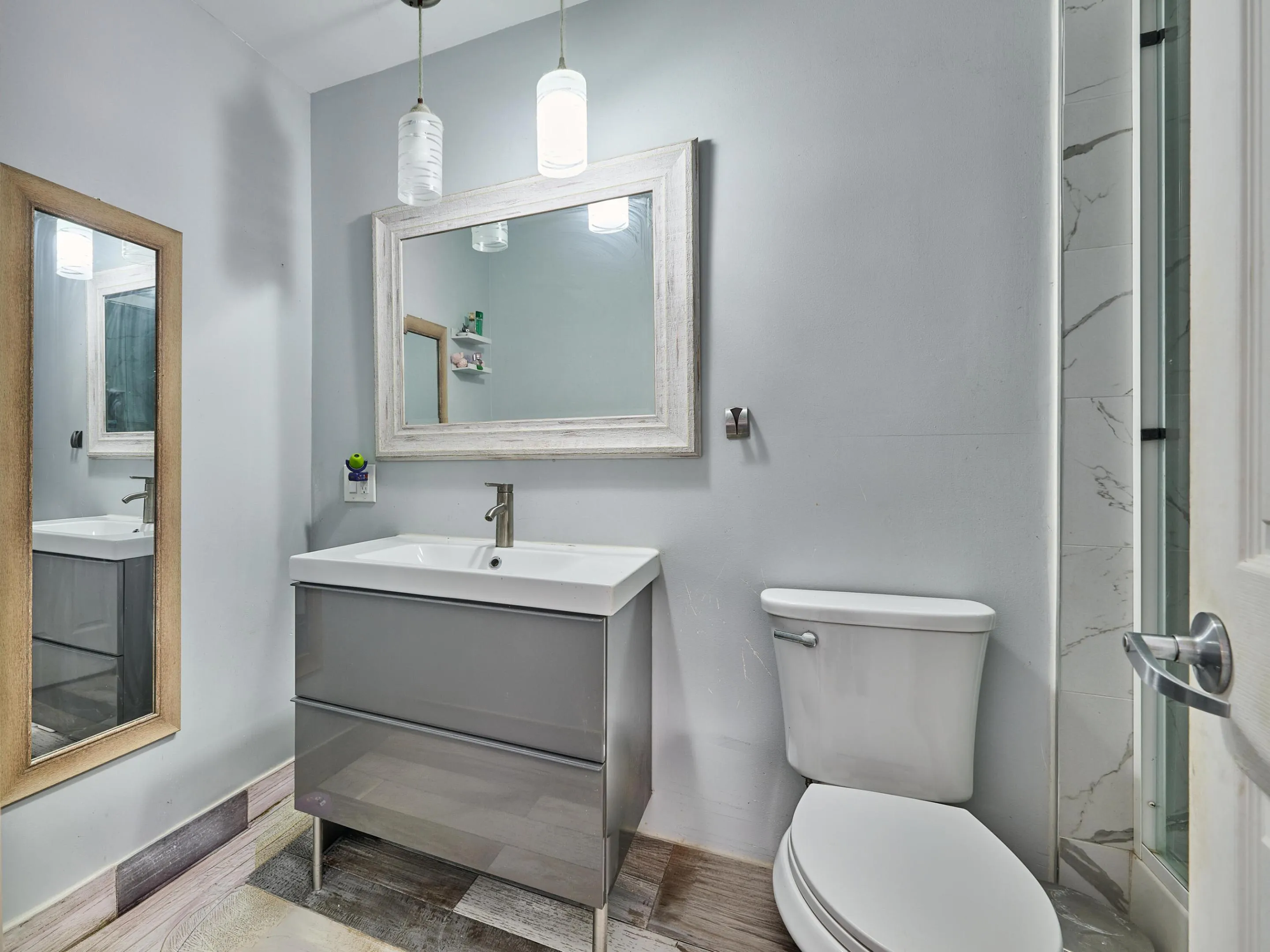 Vanity with glossy gray cabinetry, rectangular basin, and single-handle faucet
