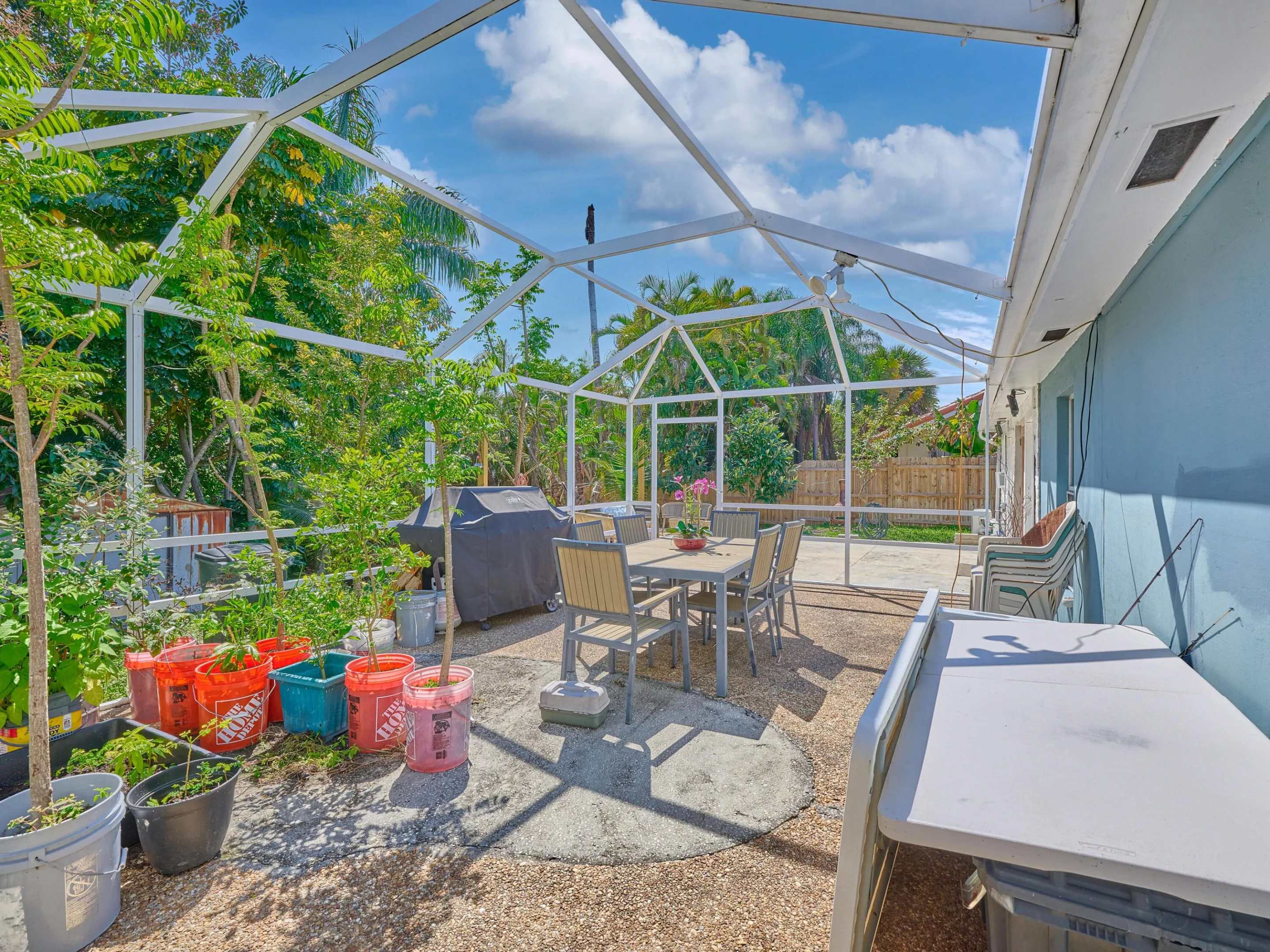 Screened patio enclosure with a textured concrete surface and lush perimeter landscaping
