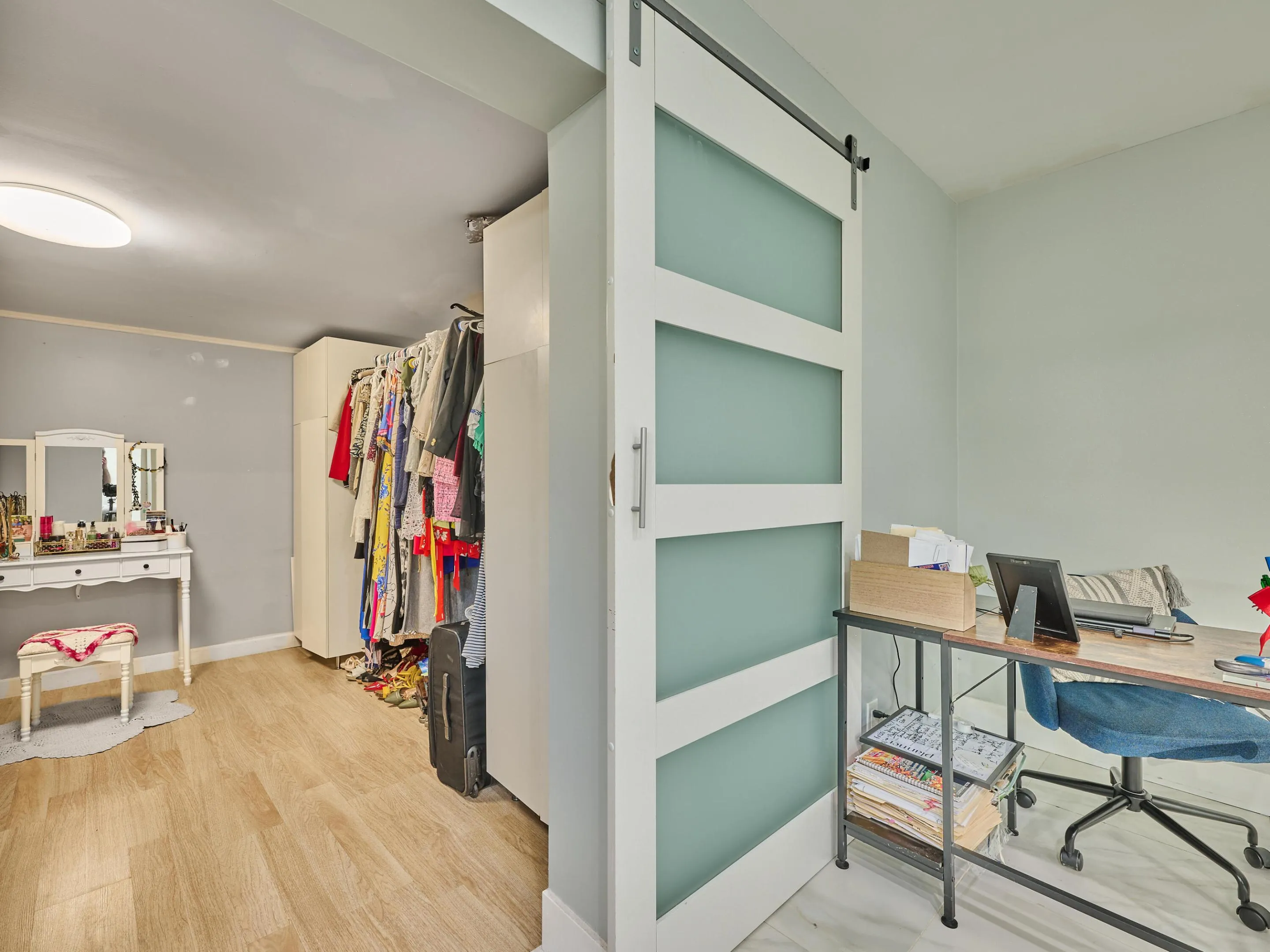 Interior featuring a contemporary barn door with frosted glass panels, wood-finish flooring, and light wall tones