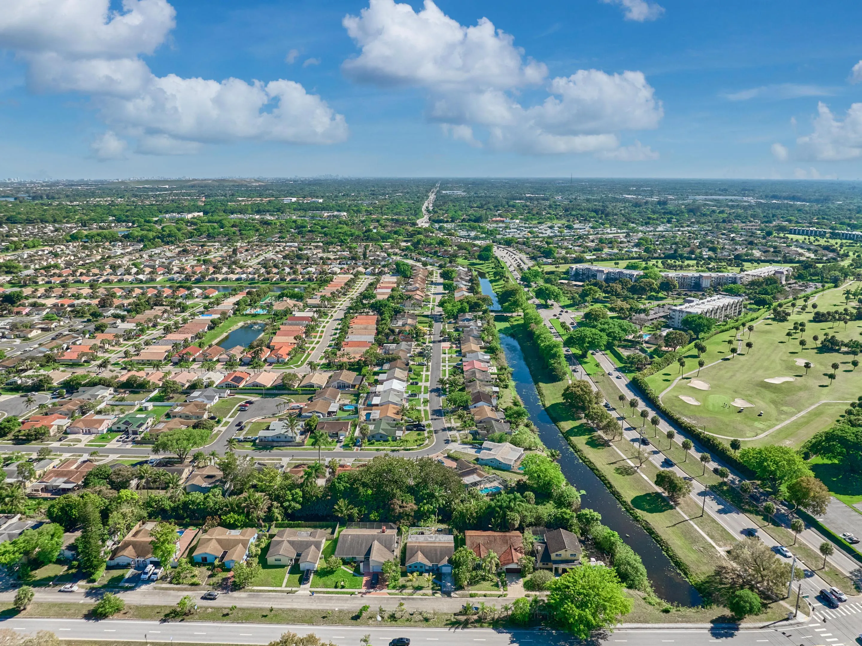 Residential area with mature trees, established canal, and a golf course