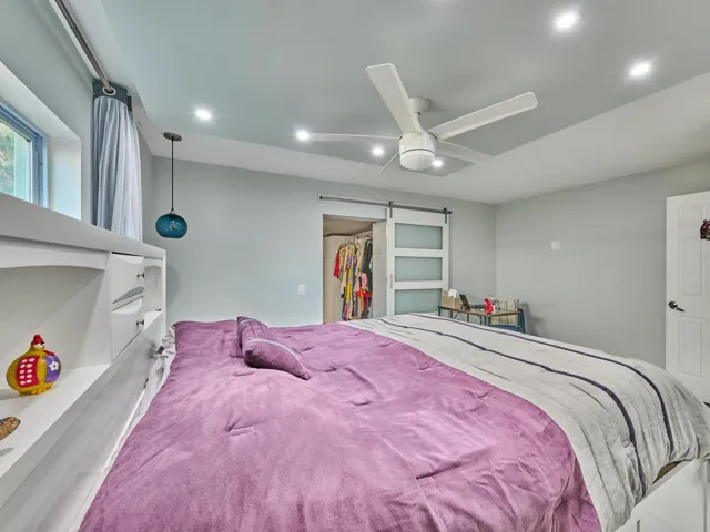 Recessed lighting and a ceiling fan illuminate this space