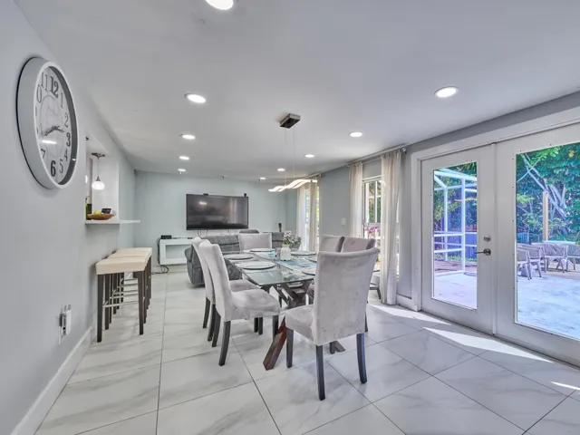 Recessed lighting throughout, tile flooring, and french doors opening to an exterior patio
