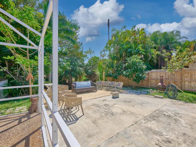 Concrete patio with a wood-finish fence and lush landscaping