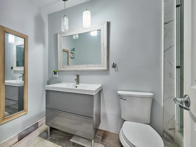 Vanity with glossy gray cabinetry, rectangular basin, and single-handle faucet