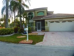 Stucco exterior with a tile roof, arched entryway, and an integrated two-car garage