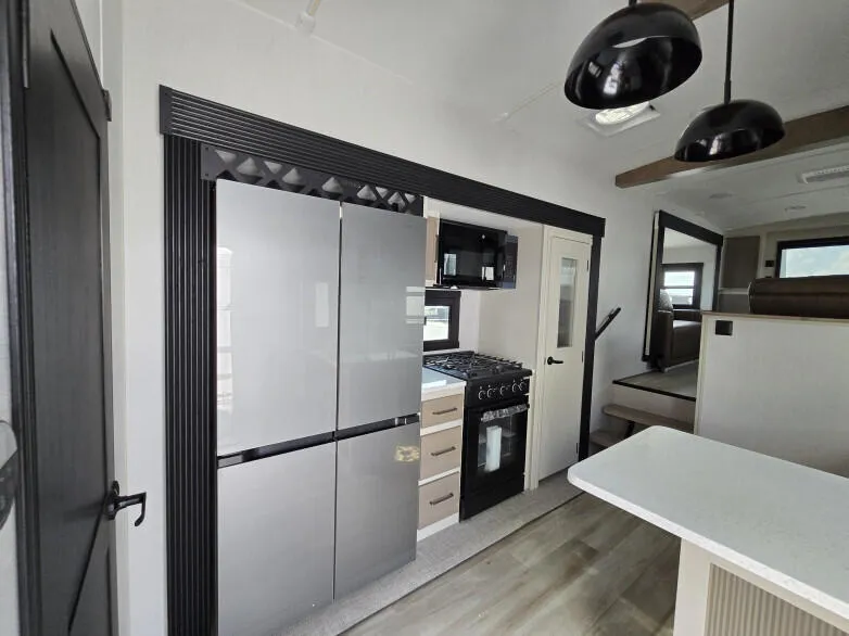 RV: Full-size double-door fridge freezer, full-size gas stove top and oven with microwave above.