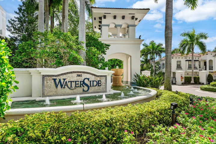 Entry monument with mosaic tile detailing, water feature with multiple fountains, and lush landscaping