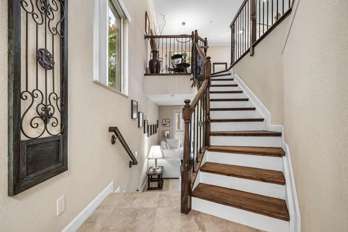 Multi-level interior featuring wood-finish stair treads and wrought iron staircase