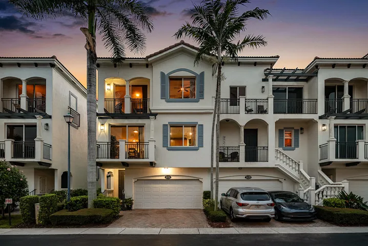 Coastal-mediterranean-inspired exterior with multi-level balconies, decorative shutters, and attached 2-car garage