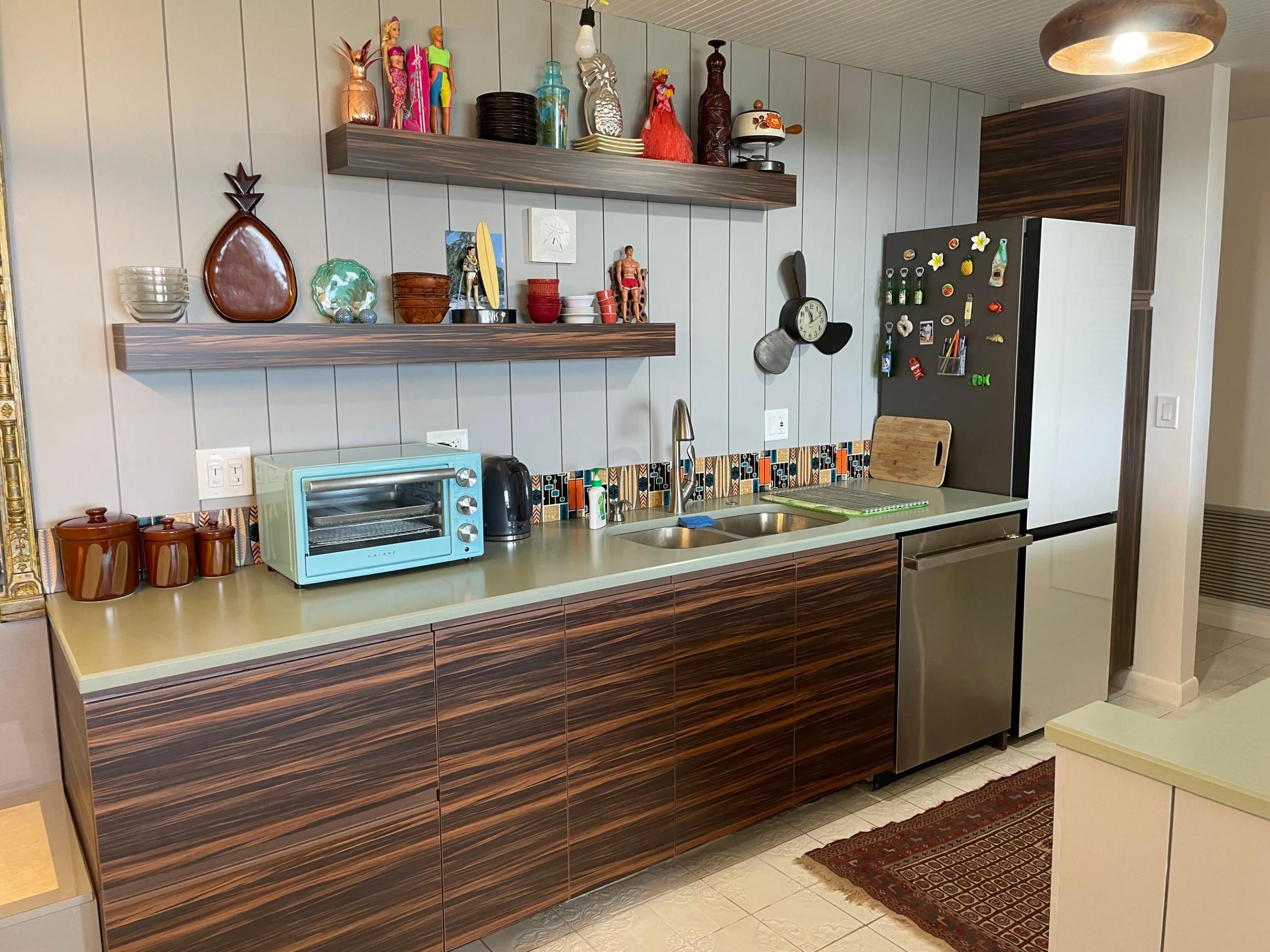 Vertical paneling, open shelving, dual basin sink, integrated dishwasher, and a refrigerator