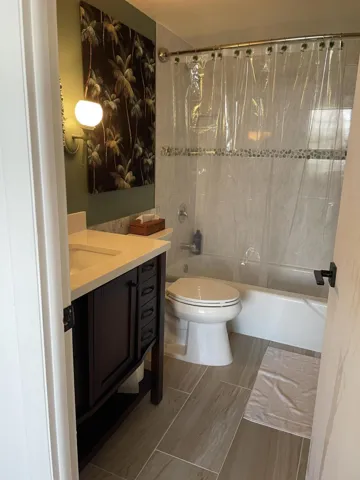 White tiled shower with a decorative accent​​‌​​​​‌​​‌‌​‌‌​​​‌‌​‌​‌​‌​​​‌​​ band