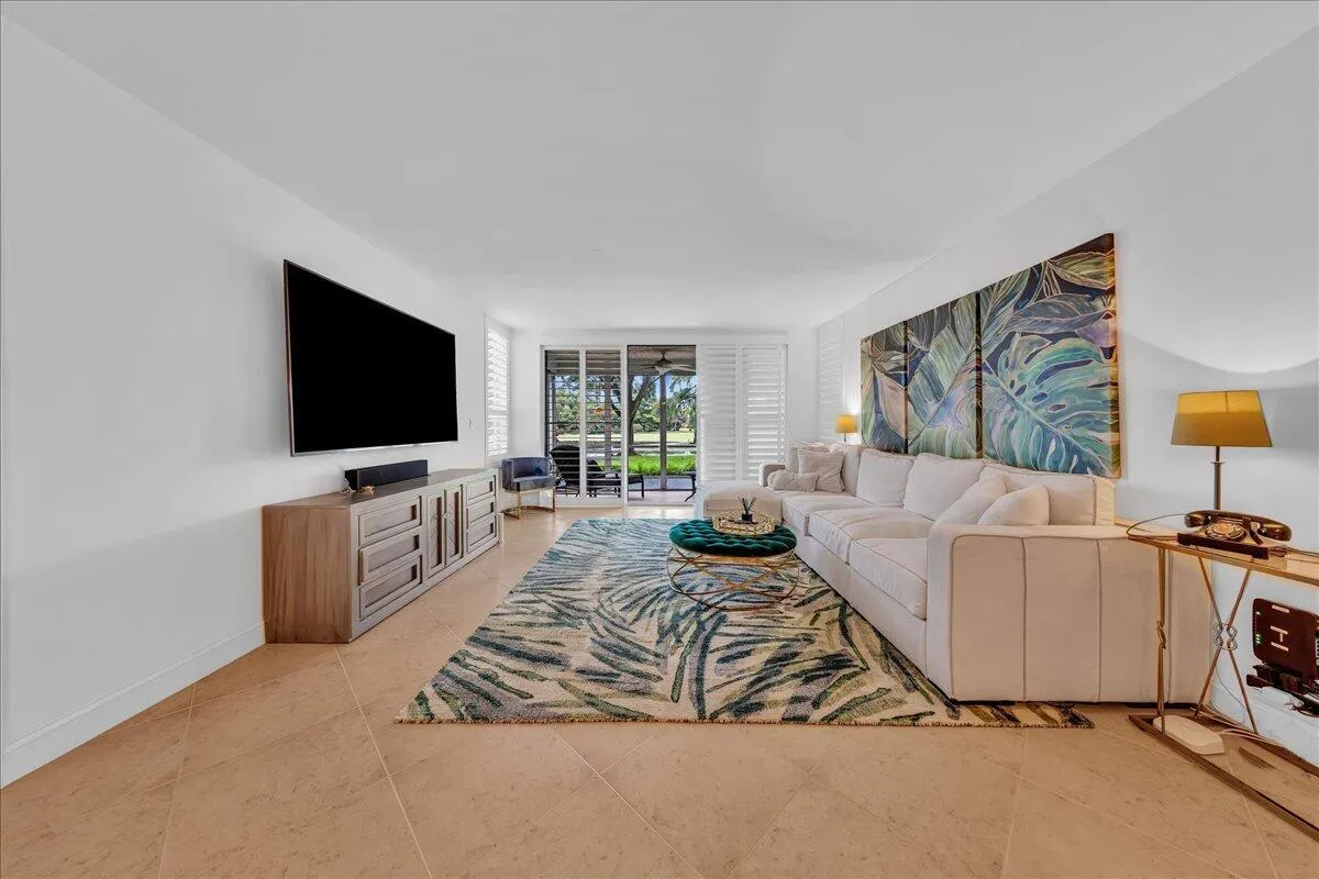 Expansive living area with neutral tile flooring and direct access to the patio