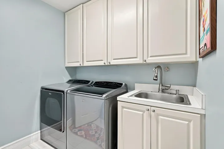 Separate laundry room with additional cabinetry and updated faucet.