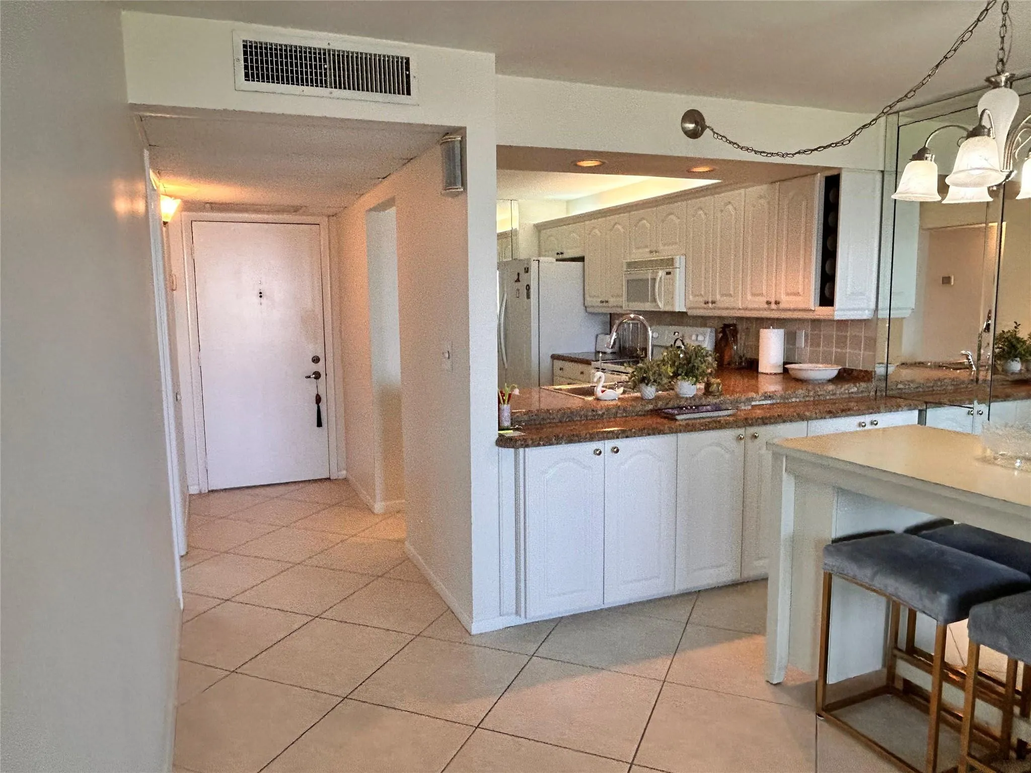 Kitchen featuring white cabinetry, integrated stainless steel appliances, and stone-finish countertops