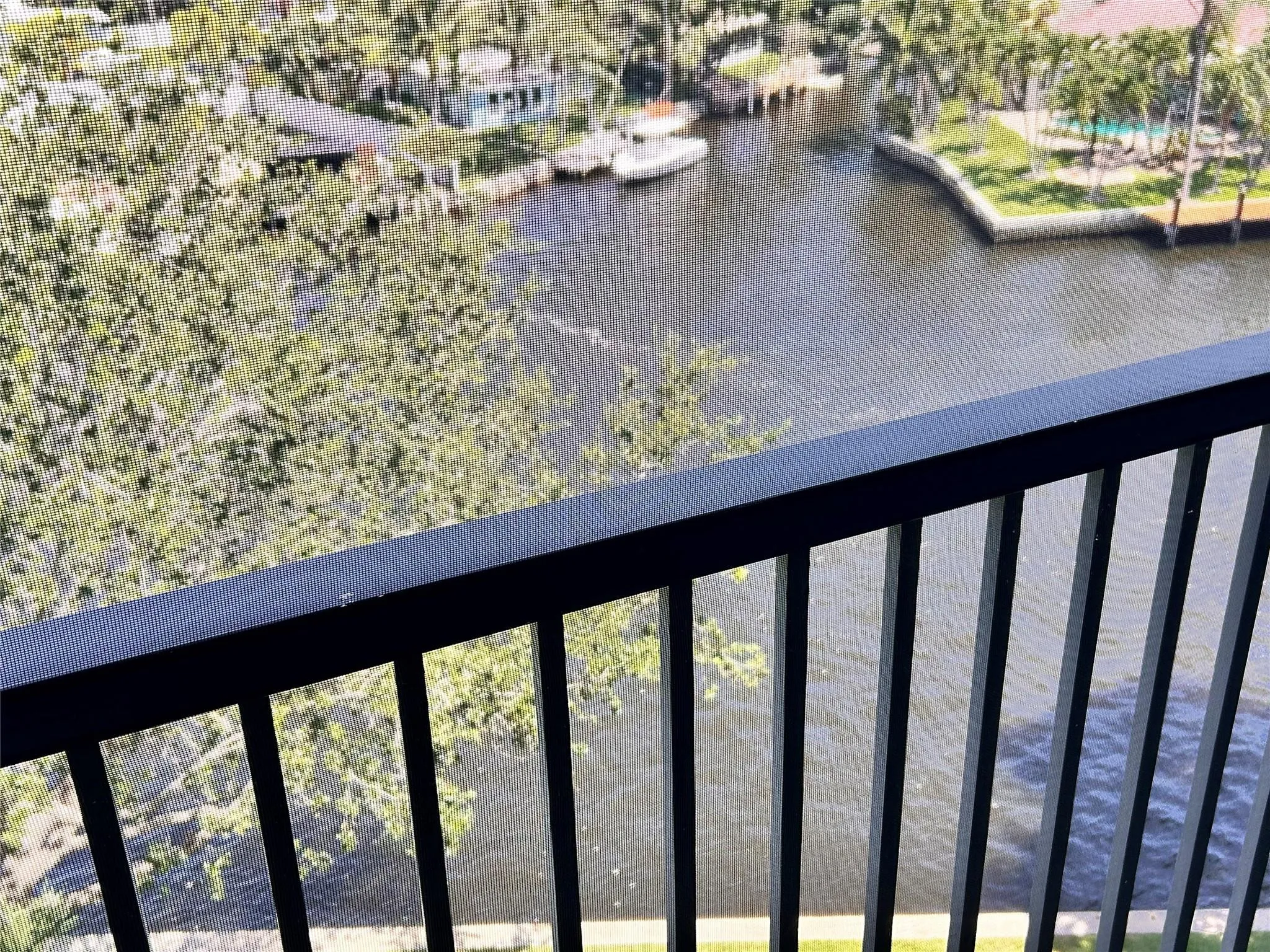 Black metal balcony railing overlooking a waterway