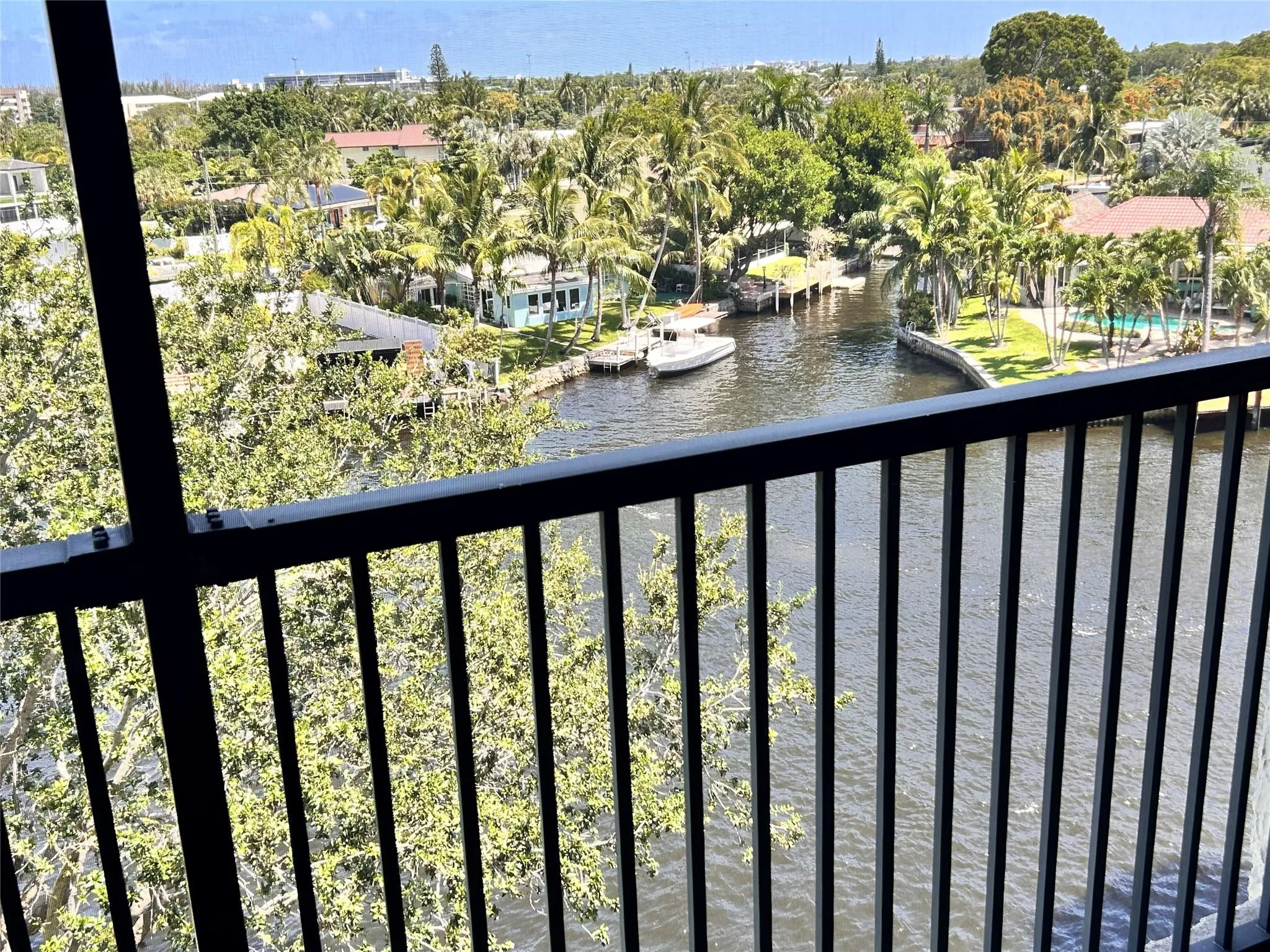 Waterfront canal, lush tropical landscaping, and mature palm trees