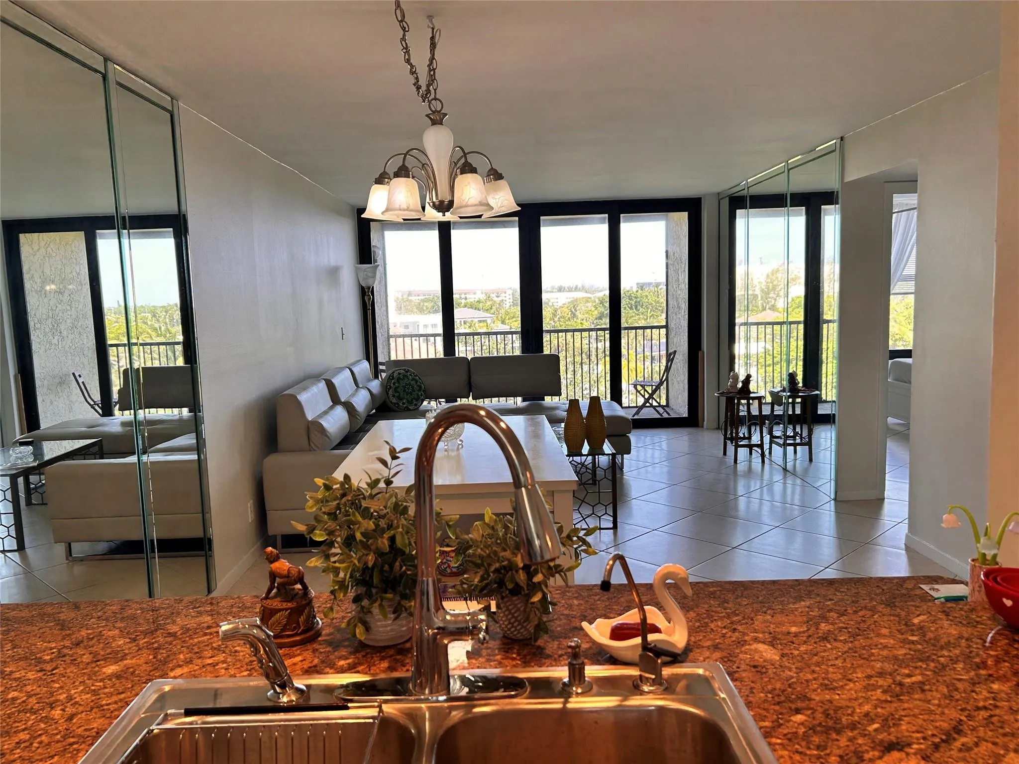 Dual basin stainless steel sink, speckled countertop, and tiled flooring