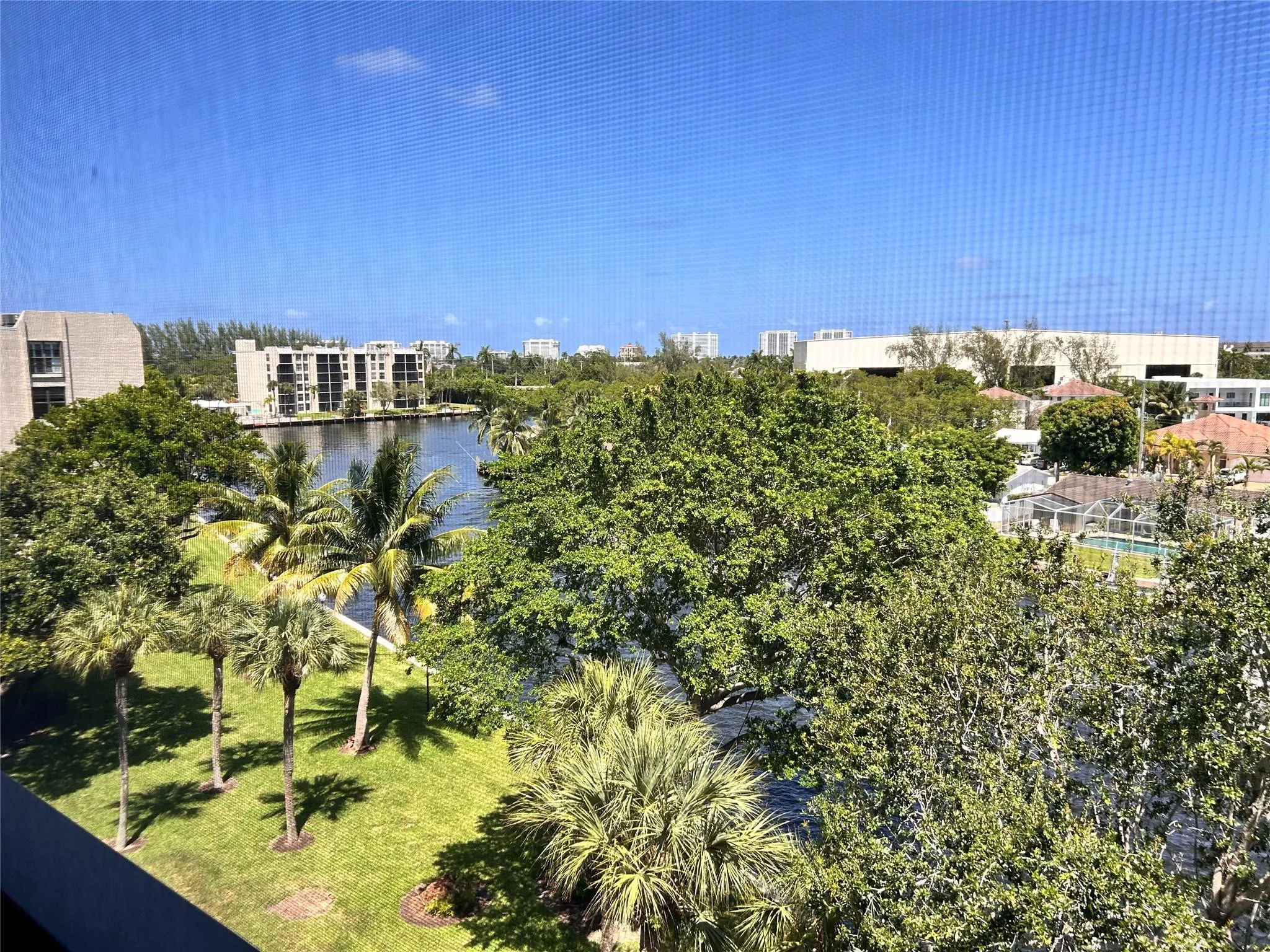 Waterfront setting with lush tropical landscaping and a clear blue sky