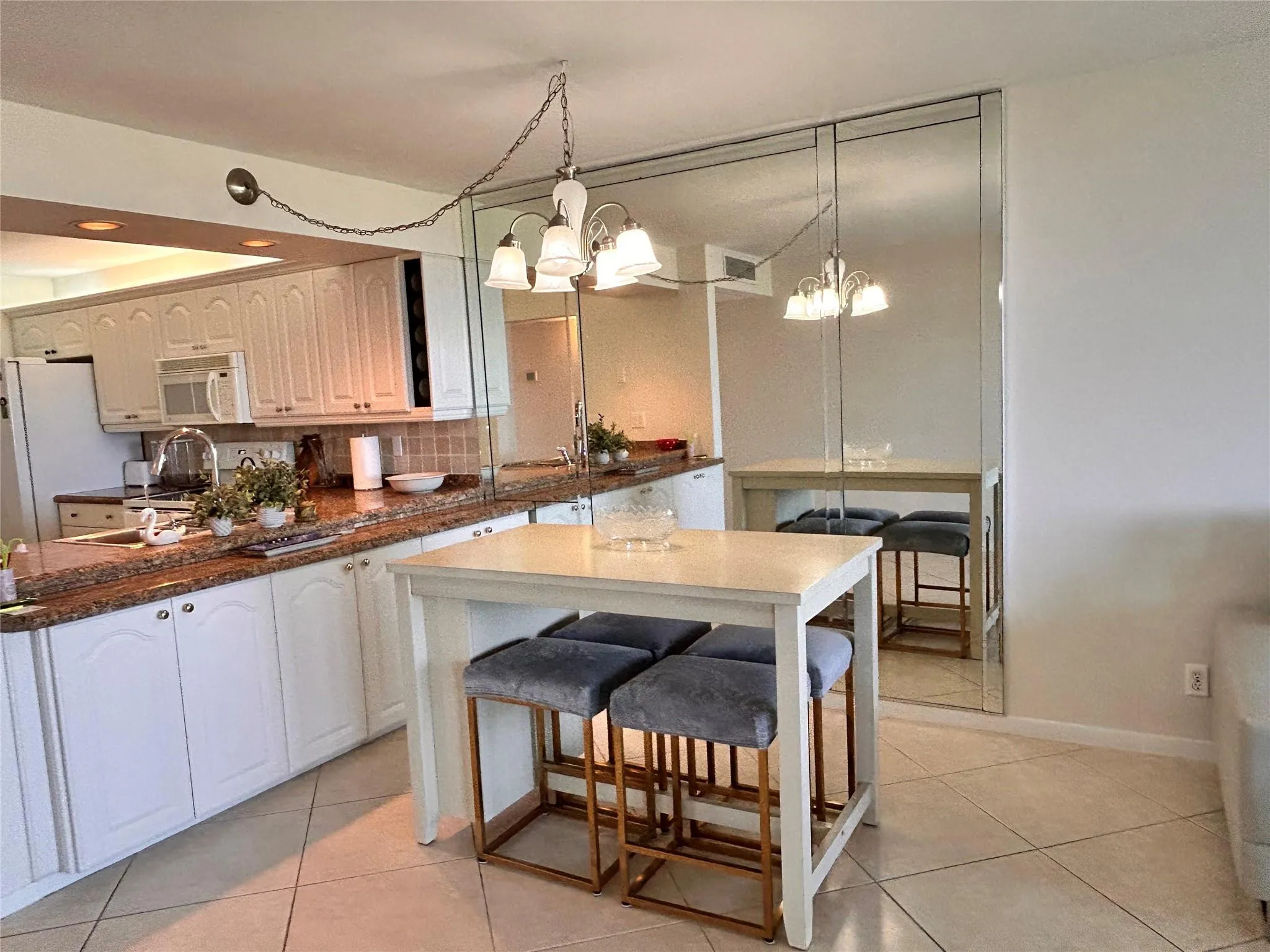 Kitchen featuring white cabinetry, brown granite countertops, tiled backsplash, and recessed lighting