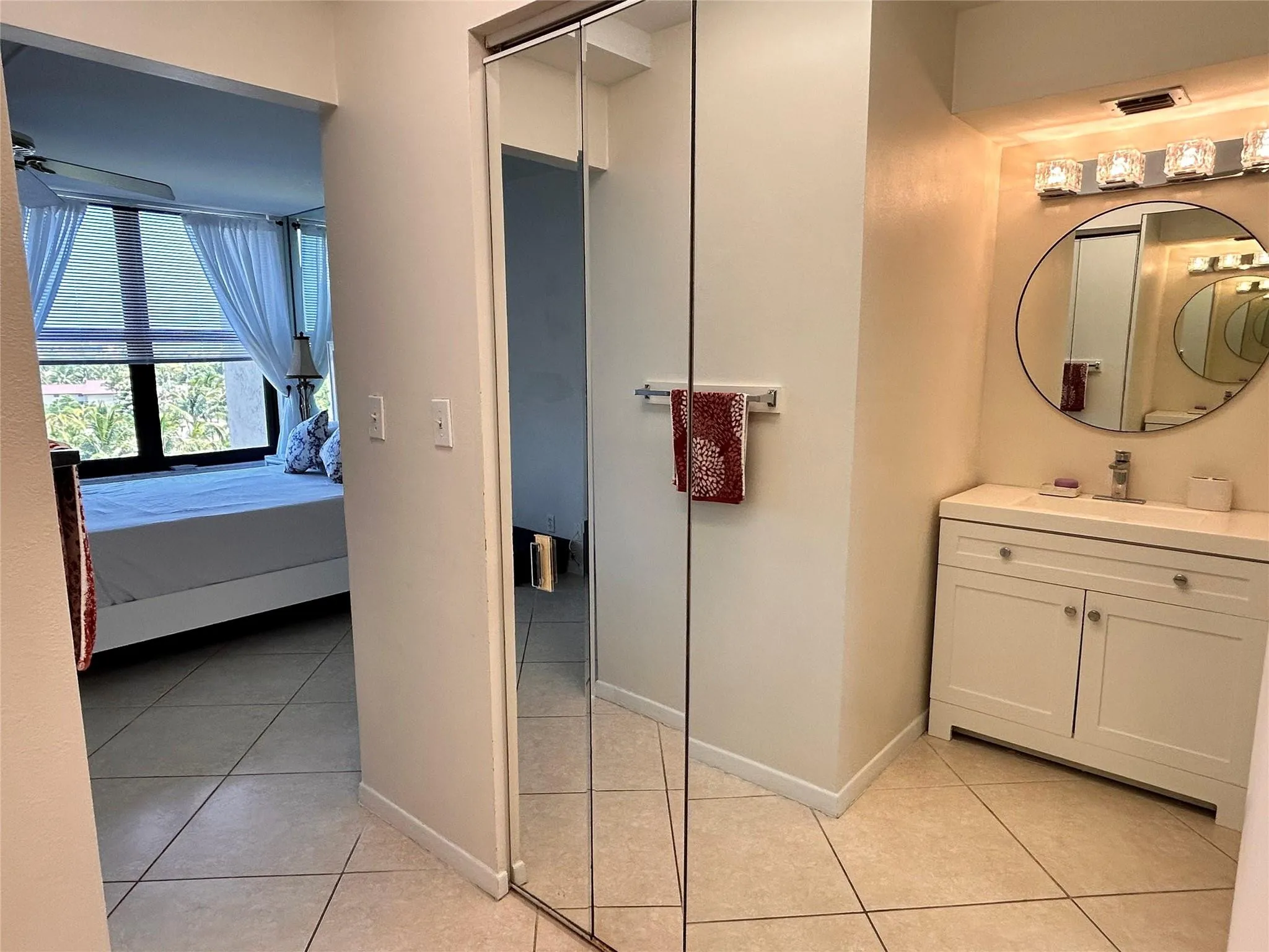 Recessed vanity with integrated sink, chrome faucet, and circular mirror