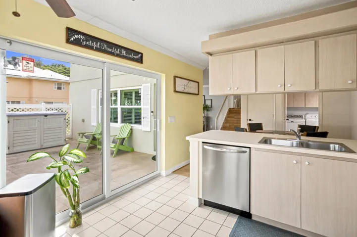 Kitchen featuring wood-finish cabinetry, stainless steel dishwasher, and a ceiling fan
