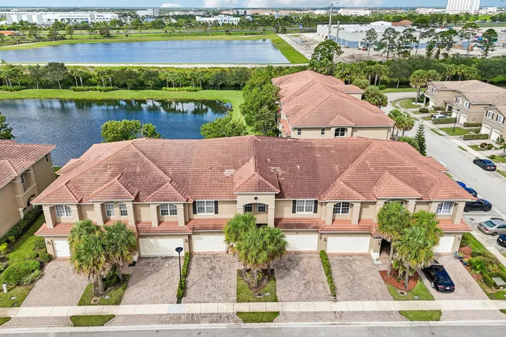 Townhome exteriors with barrel tile roofing, paver driveways, and attached garages